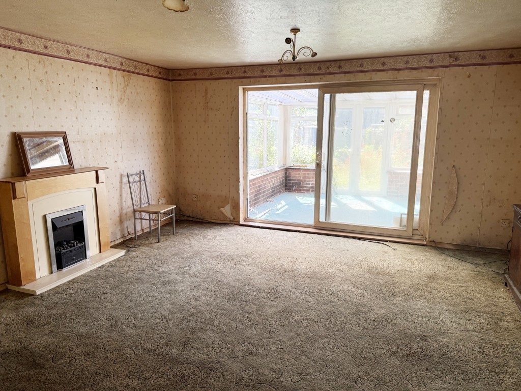 Lot: 25 - TERRACE HOUSE FOR REPAIR AND REFURBISHMENT WITH GARAGE - Living room leading to conservatory and garden